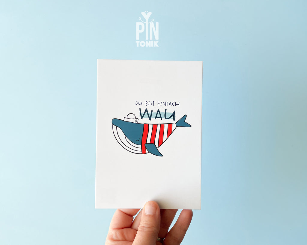 Premium postcard with an original illustration of a blue whale wearing a red striped shirt and a sailor hat with the text 'DU BIST EINFACH WAU'.