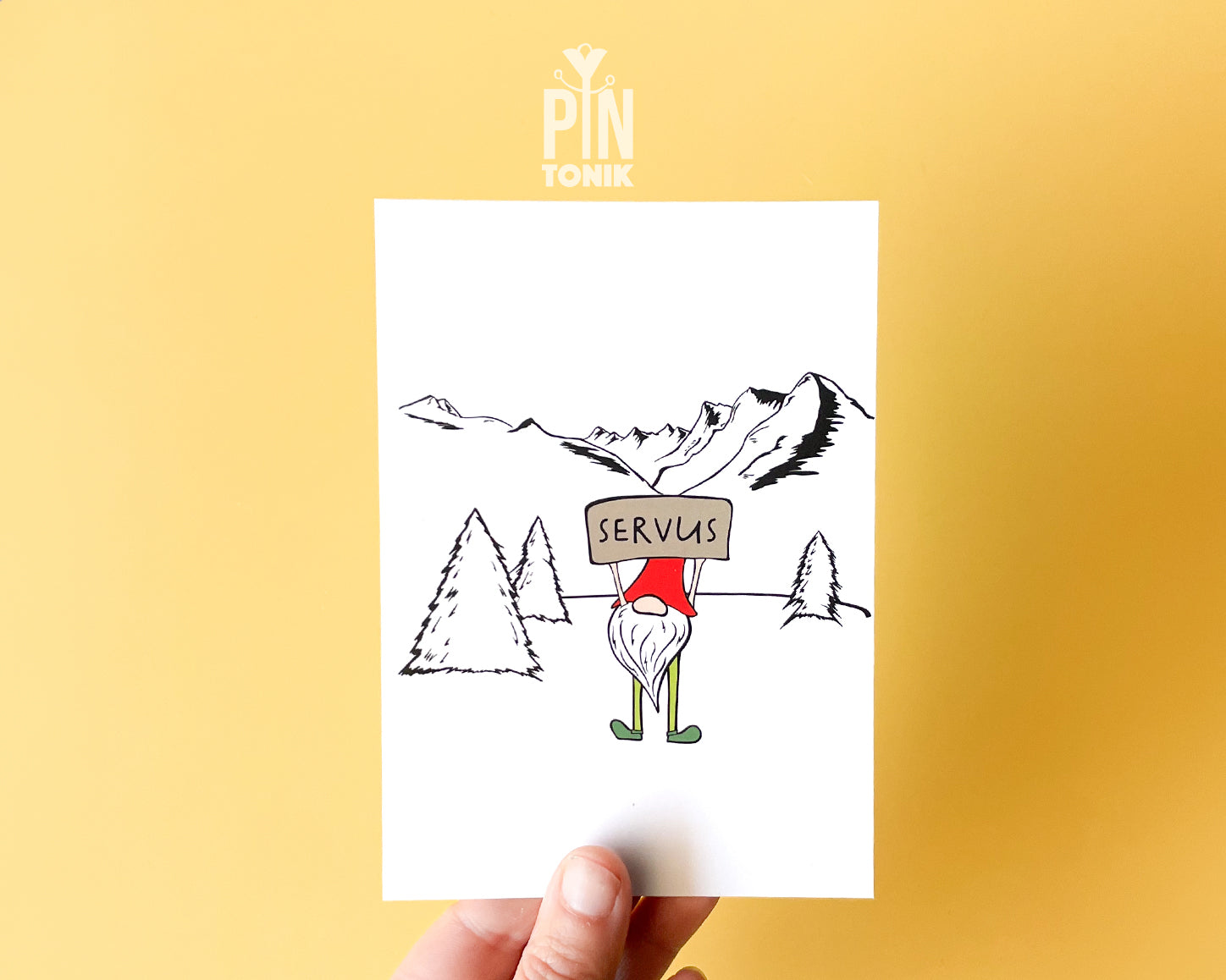 Premium postcard with an original illustration of a mountain gnome holding a 'SERVUS' sign in a snowy alpine landscape.