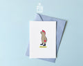 Premium postcard with an original illustration of a capybara with a pink mohawk and boots with the text 'OKIDOKI', shown with a light blue luxury envelope on a light blue background.