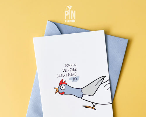 Premium postcard with an original illustration of a chicken and the German text 'SCHON WIEDER GEBURTSTAG. JO.', shown against a yellow background with a light blue envelope