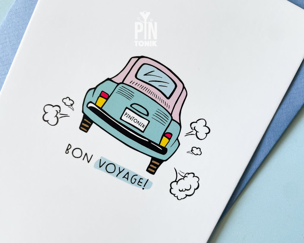 Premium postcard with an original illustration of a light blue retro car and the text 'Bon Voyage!', shown held against a light blue background.