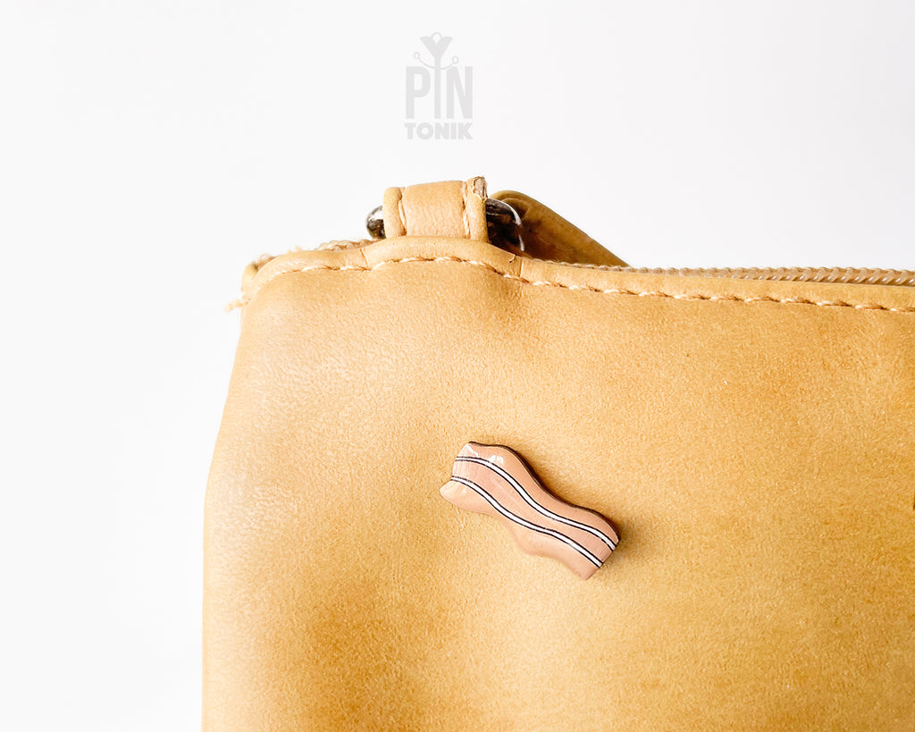 Hand-painted wavy wooden bacon strip pin with tan and white marbled details and a high-gloss finish