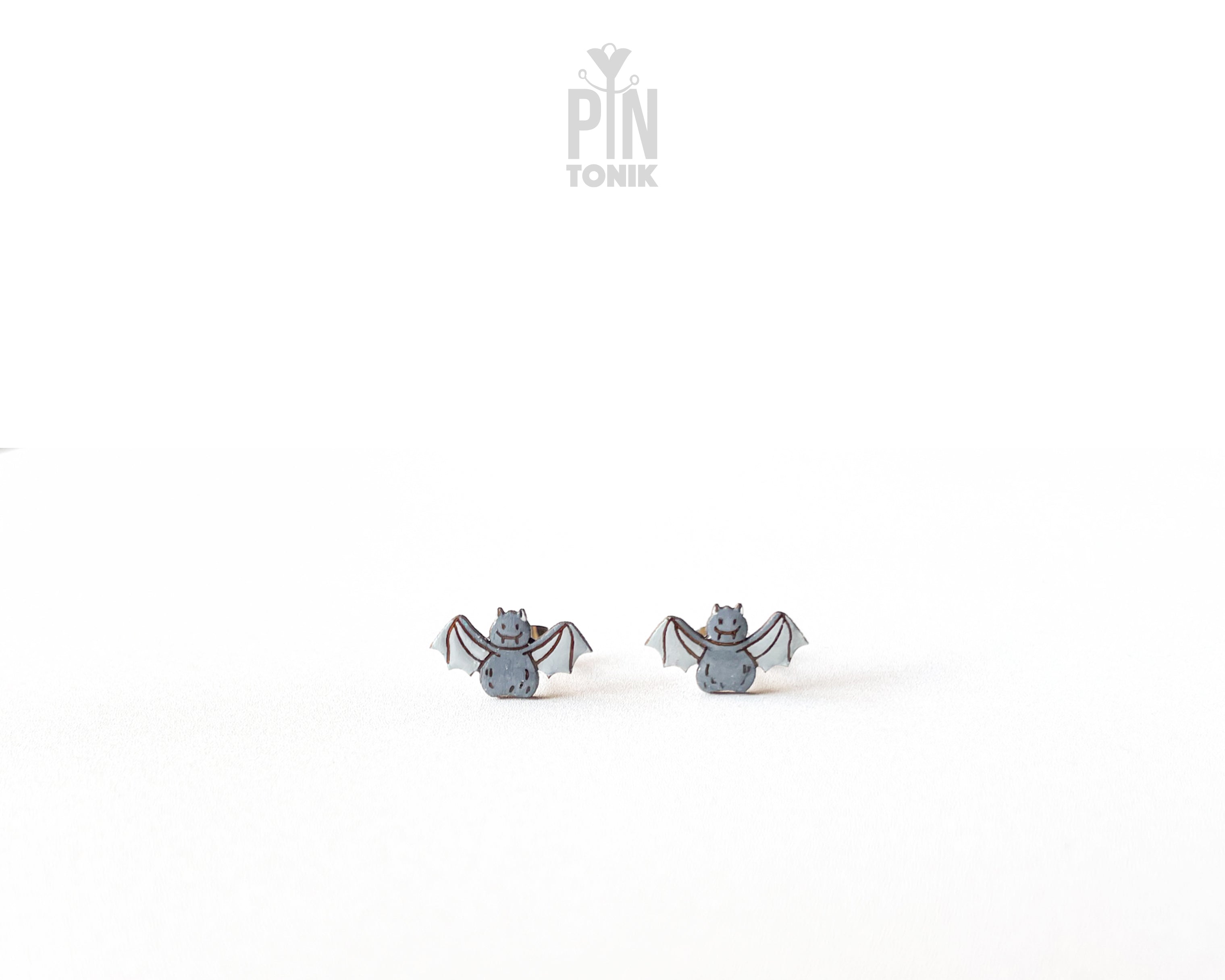 Handmade wooden grey bat stud earrings with outstretched wings by PinTonik, playful spooky and animal themed jewelry.
