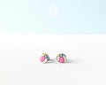 Handmade wooden beach ball stud earrings featuring a cheerful striped pattern of pink, white, and gray panels by PinTonik.