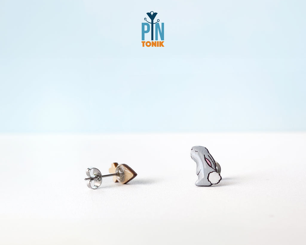 Mismatched hand-painted wooden stud earrings featuring a grey bunny and a bright orange carrot