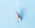 Hand-painted grey wooden bunny pin with a fluffy white tail and glossy resin finish