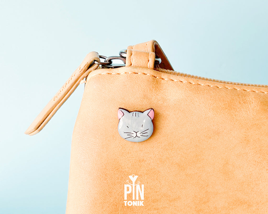 Hand-painted grey wooden cat pin with a high-gloss protective resin finish and a judgmental expression