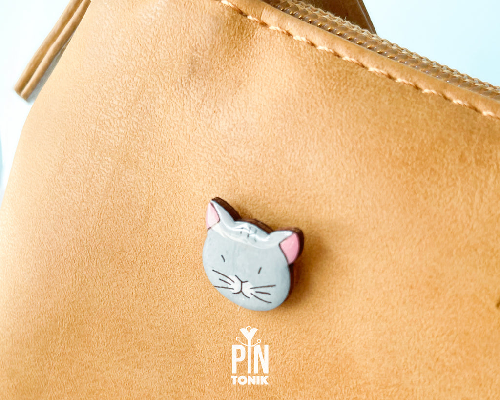 Hand-painted grey wooden cat pin with a high-gloss protective resin finish and a judgmental expression