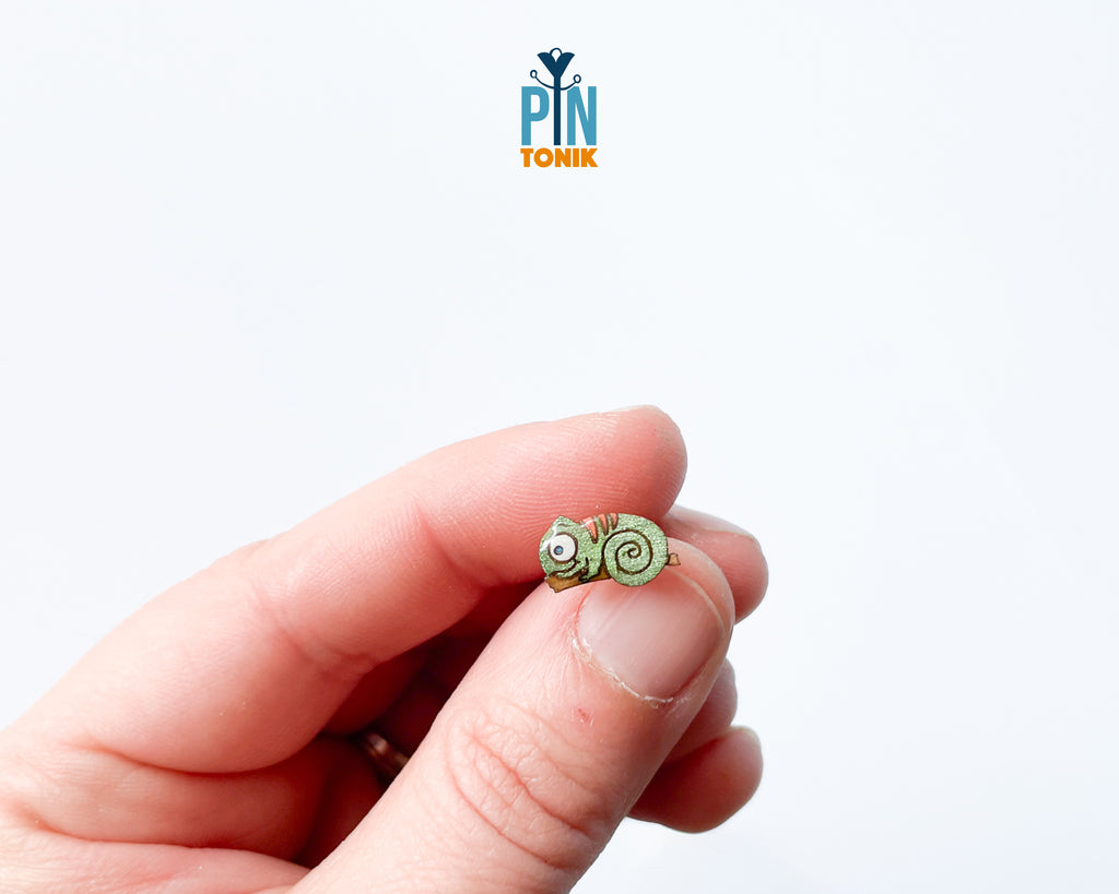 Pair of hand-painted green wooden chameleon stud earrings with a curly tail and glossy resin finish