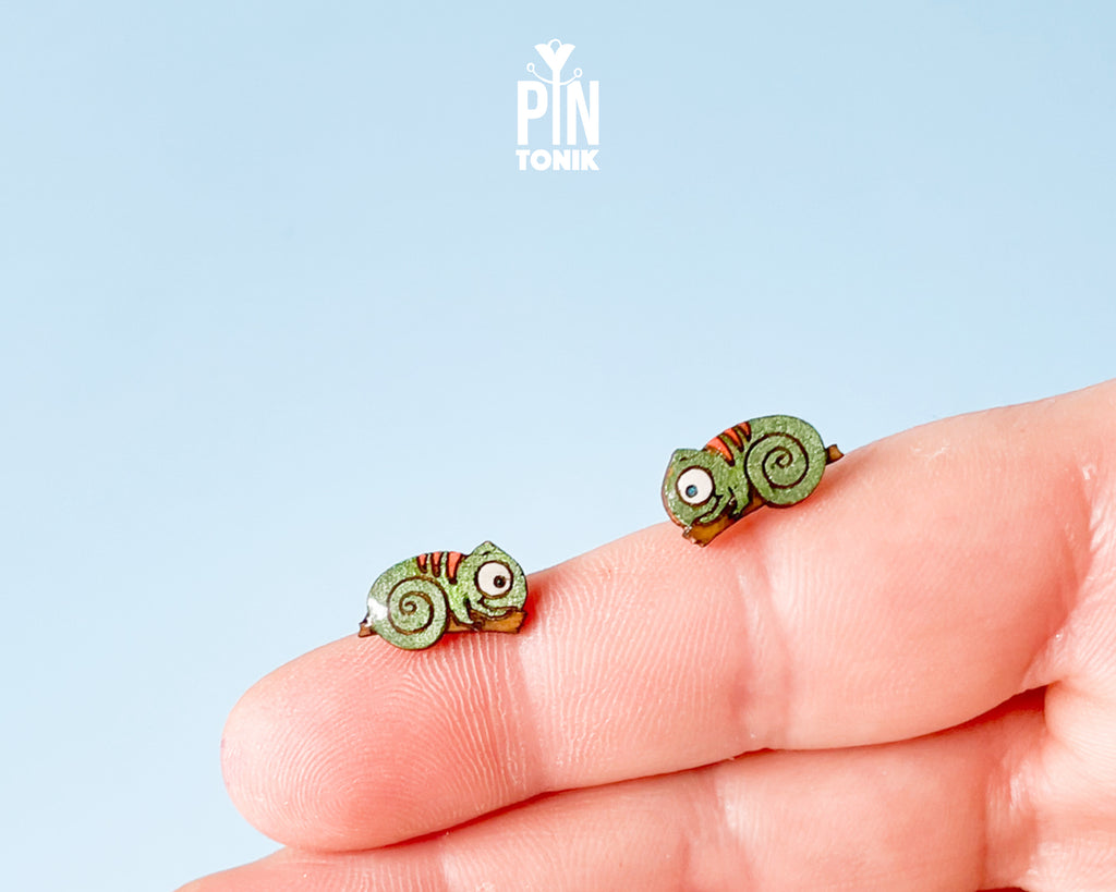Pair of hand-painted green wooden chameleon stud earrings with a curly tail and glossy resin finish
