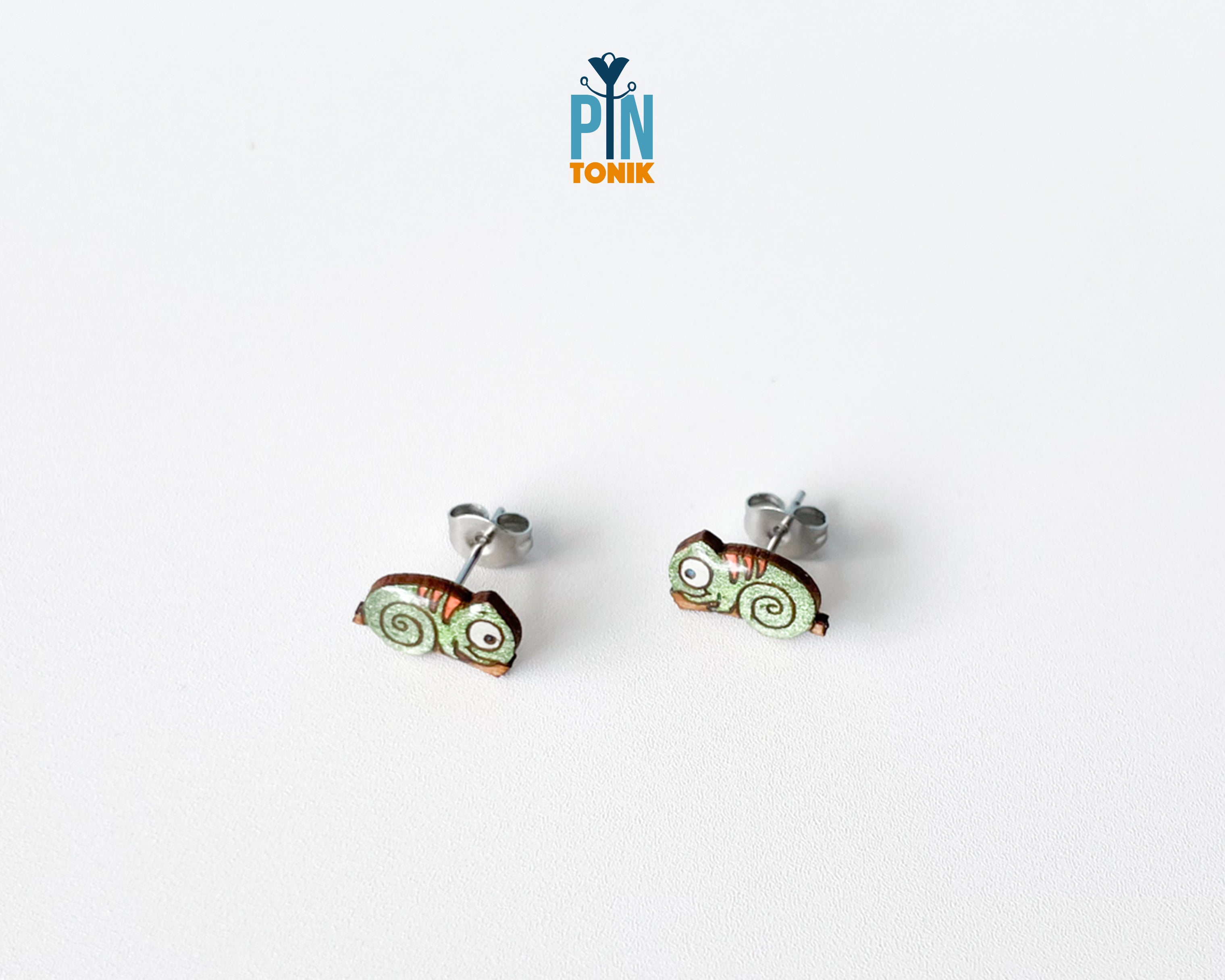 Pair of hand-painted green wooden chameleon stud earrings with a curly tail and glossy resin finish