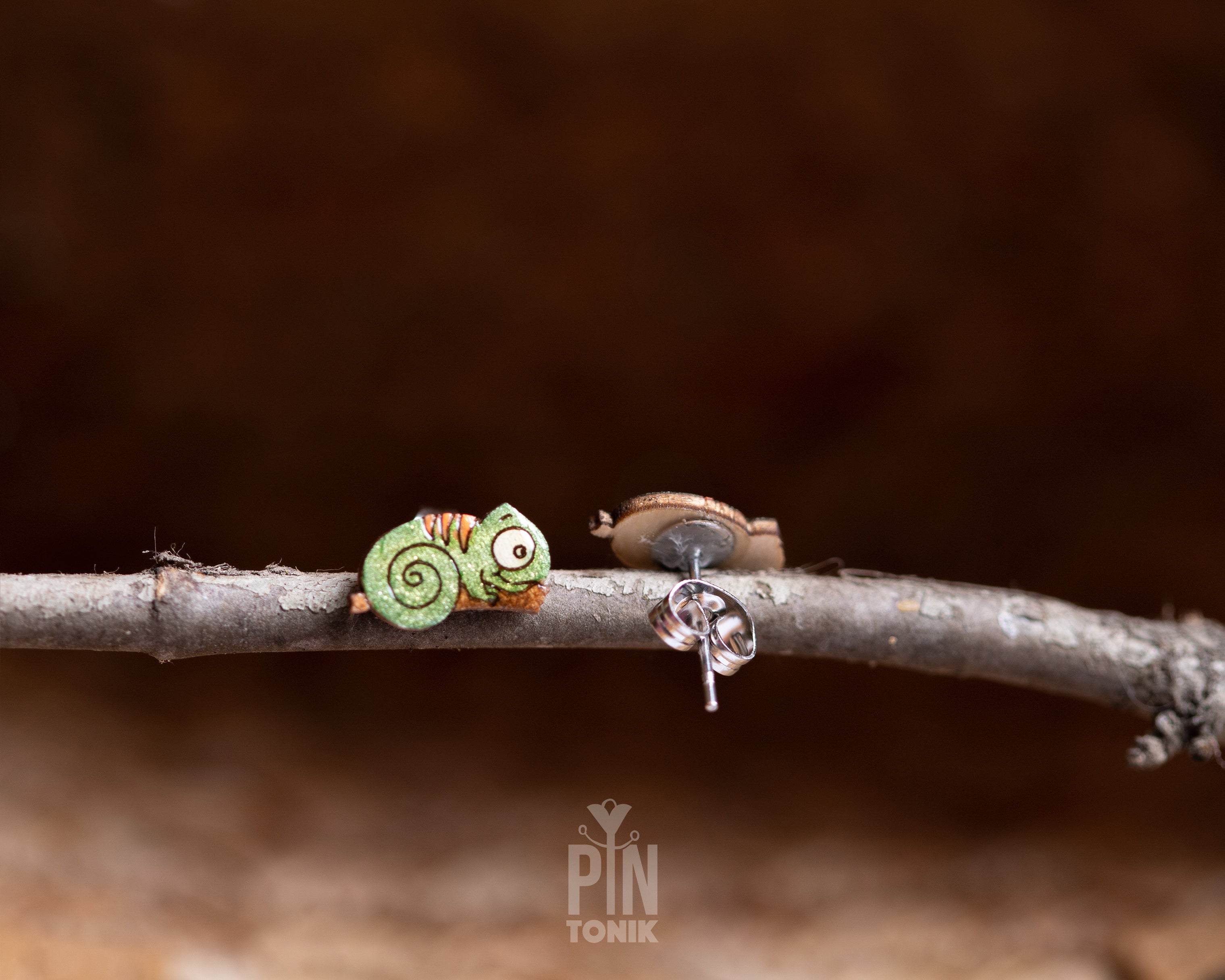 Pair of hand-painted green wooden chameleon stud earrings with a curly tail and glossy resin finish