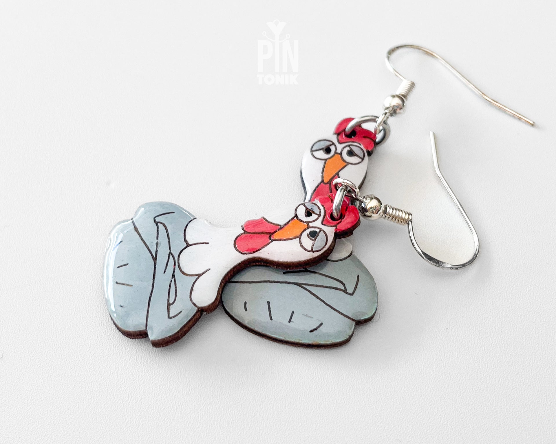 Large hand-painted wooden chicken dangle earrings with a grumpy expression and sterling silver hooks
