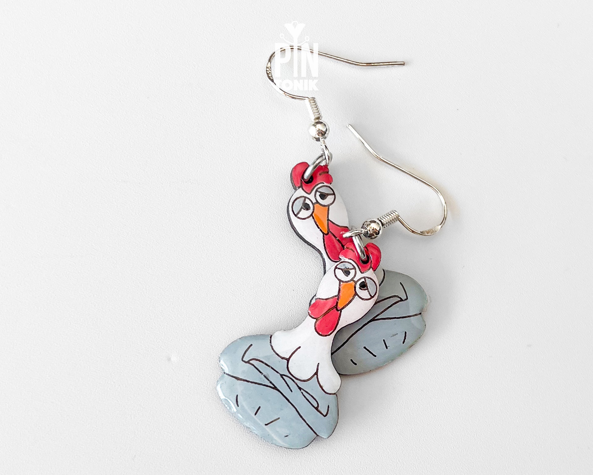 Large hand-painted wooden chicken dangle earrings with a grumpy expression and sterling silver hooks