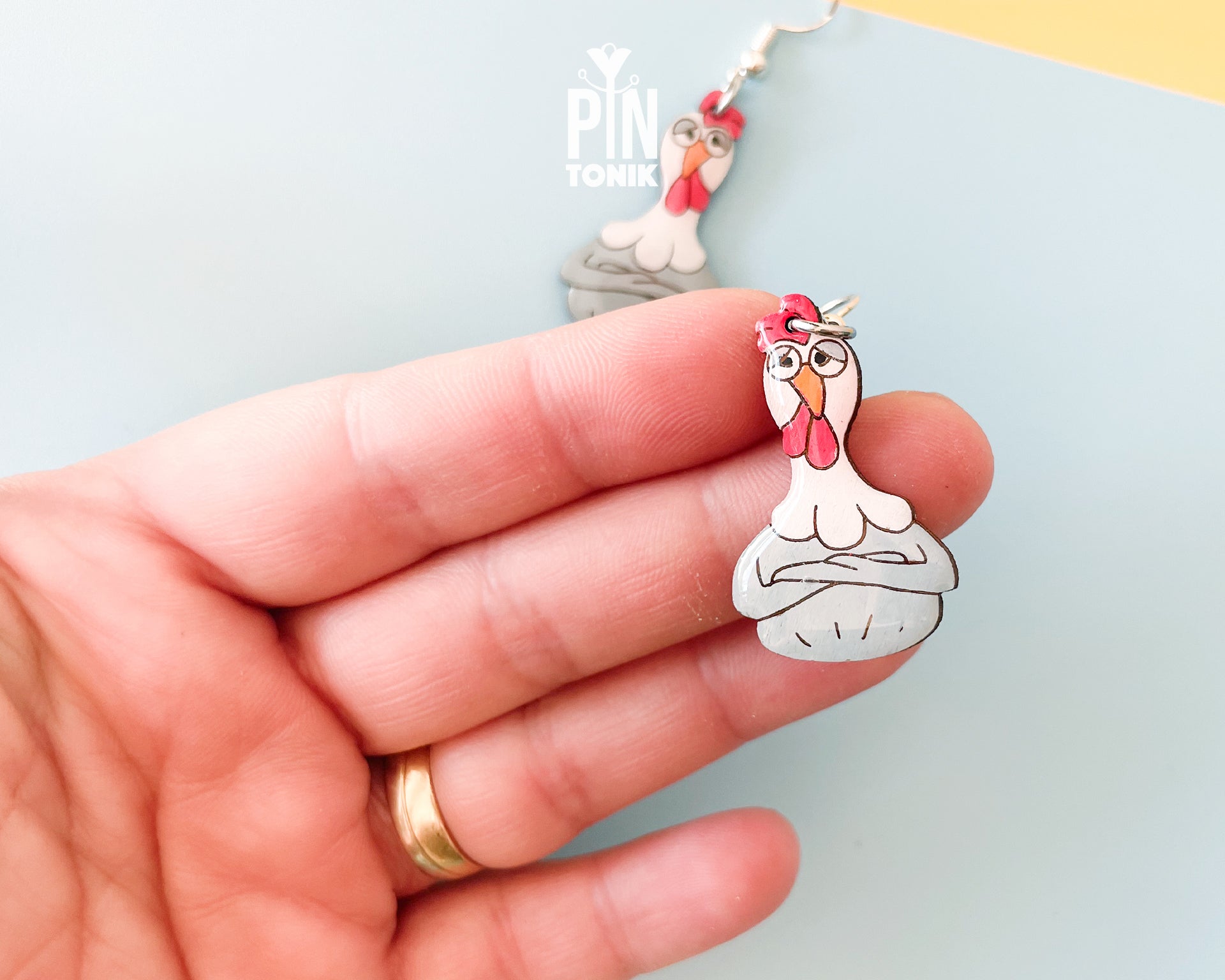 Large hand-painted wooden chicken dangle earrings with a grumpy expression and sterling silver hooks