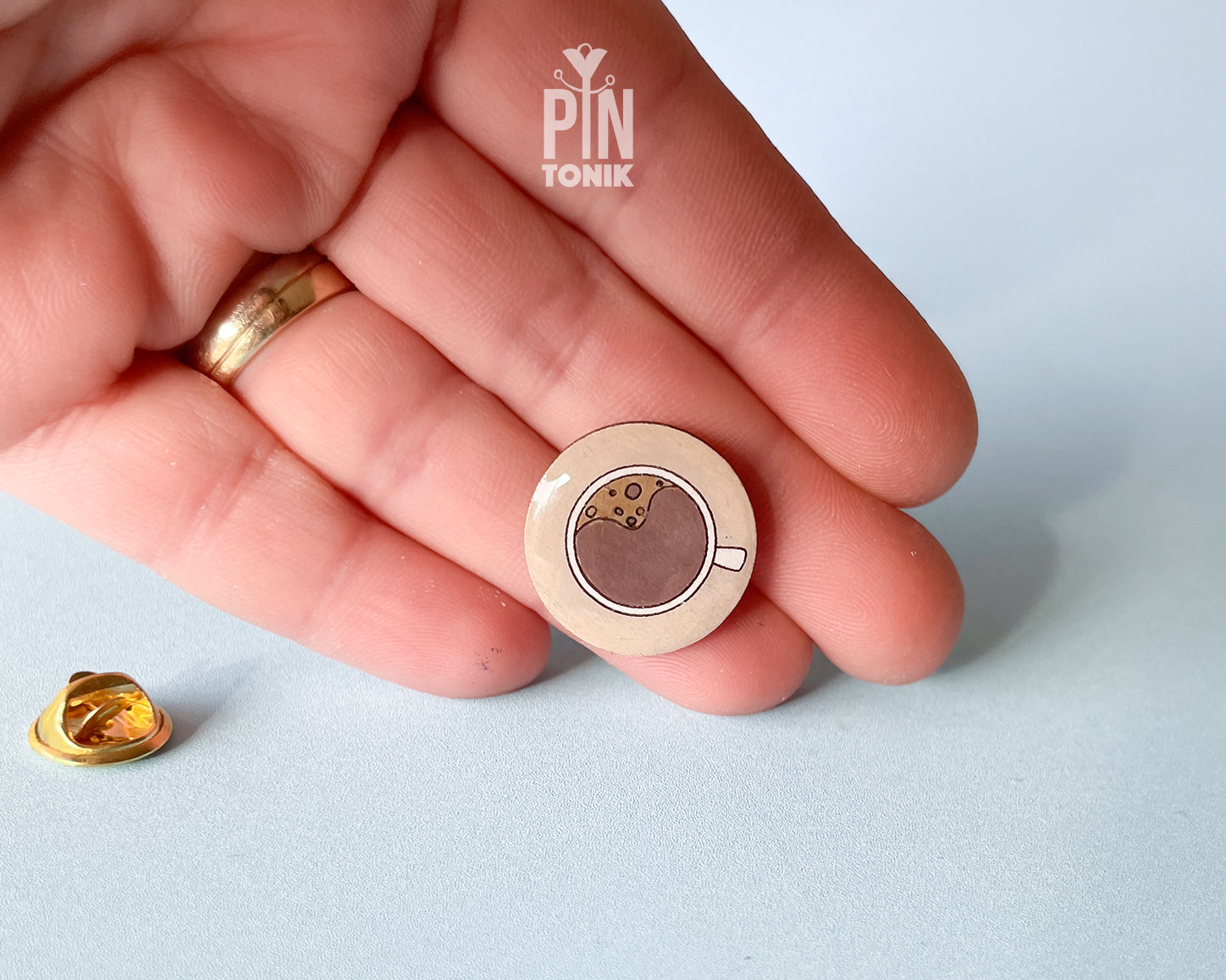 Hand-painted wooden coffee cup pin with latte art and a glossy resin finish