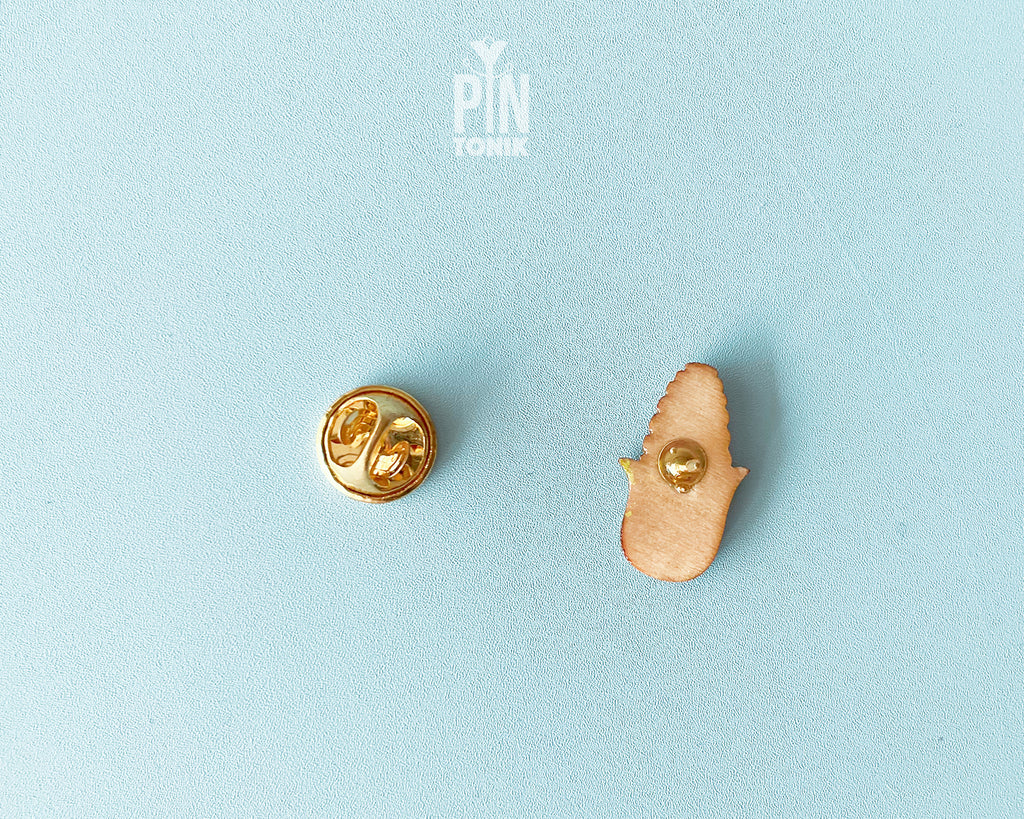 Hand-painted wooden pin of an ear of corn with bright green husks and a high-gloss resin finish
