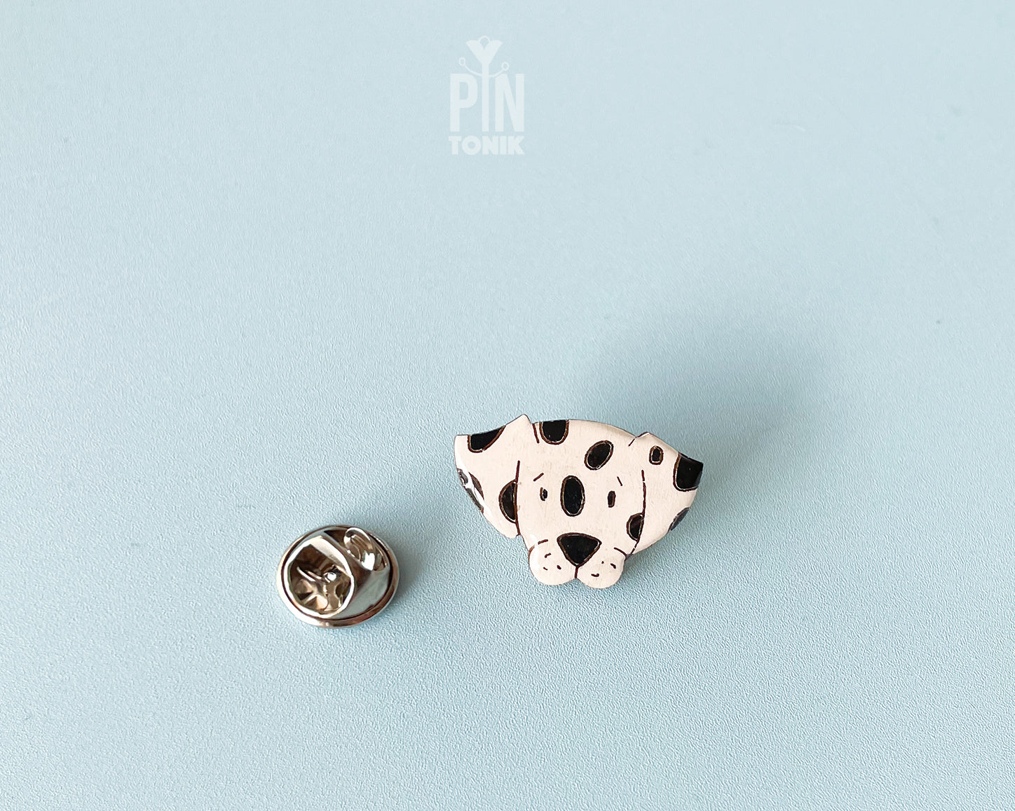 Hand-painted wooden dalmatian dog pin with black spots and a high-gloss resin finish