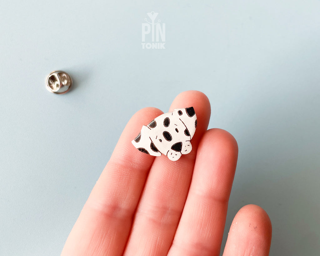 Hand-painted wooden dalmatian dog pin with black spots and a high-gloss resin finish