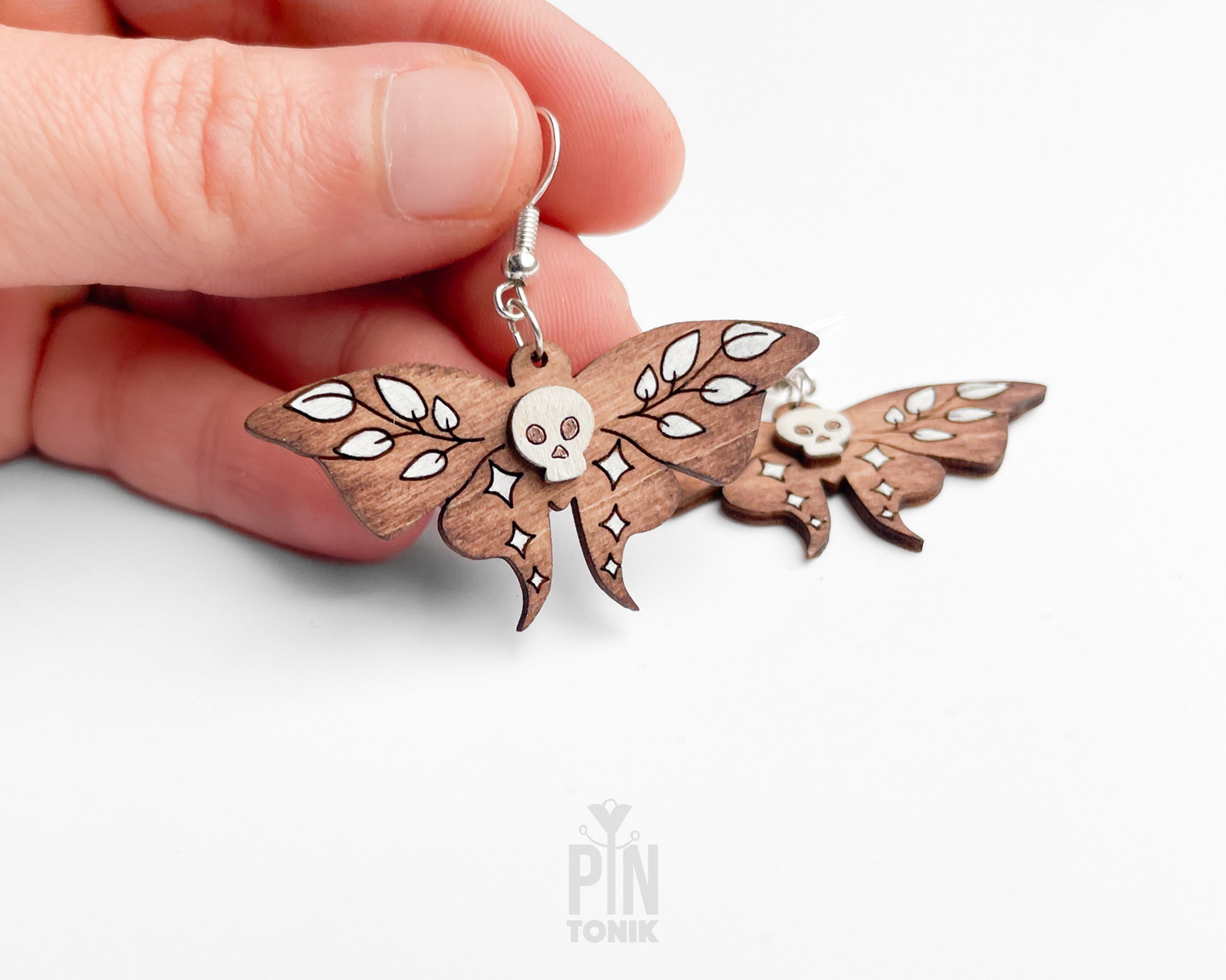 Hand-painted wooden Death's-head Hawkmoth dangle earrings with white skull and wing details on sterling silver hooks