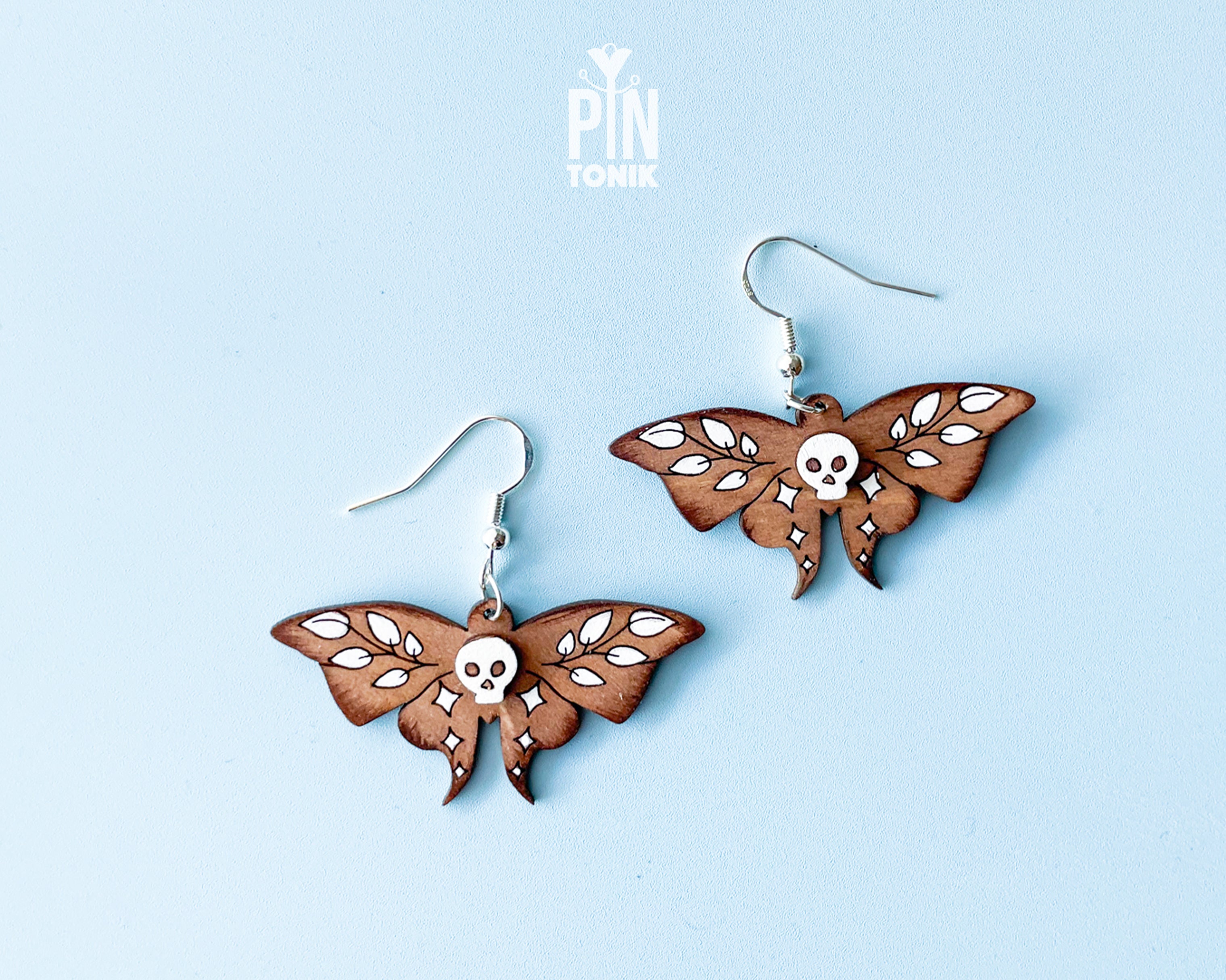 Hand-painted wooden Death's-head Hawkmoth dangle earrings with white skull and wing details on sterling silver hooks