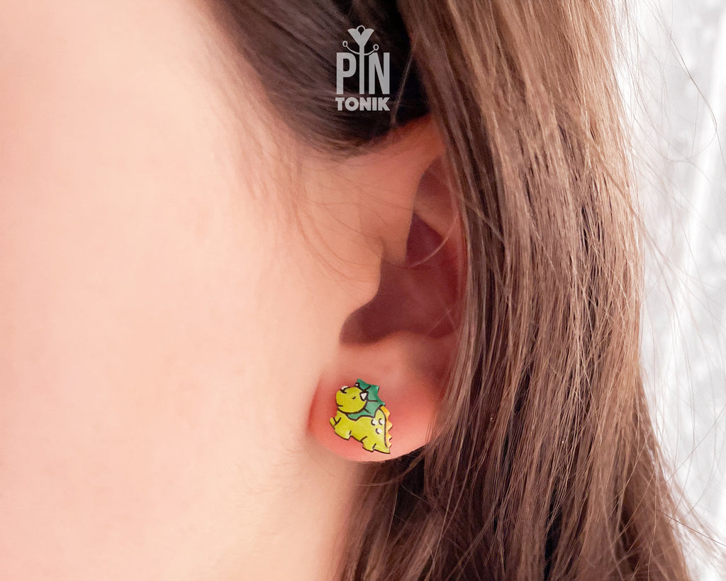 Pair of hand-painted green wooden triceratops dinosaur stud earrings with a high-gloss resin finish