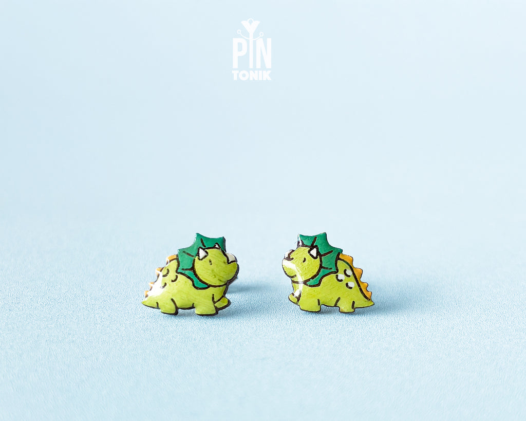 Pair of hand-painted green wooden triceratops dinosaur stud earrings with a high-gloss resin finish