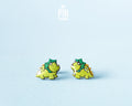 Pair of hand-painted green wooden triceratops dinosaur stud earrings with a high-gloss resin finish
