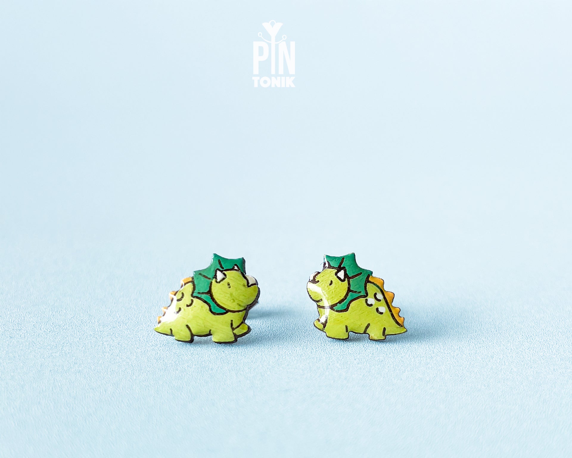 Pair of hand-painted green wooden triceratops dinosaur stud earrings with a high-gloss resin finish