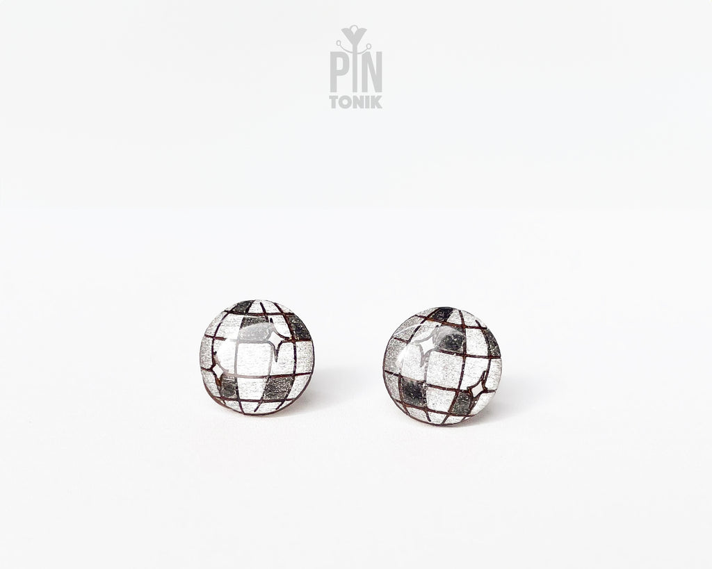 A pair of round stud earrings with a mirrored disco ball design, featuring reflective silver tiles and dark grid lines, shown on a plain white background with a 'PIN TONIK' watermark at the top.
