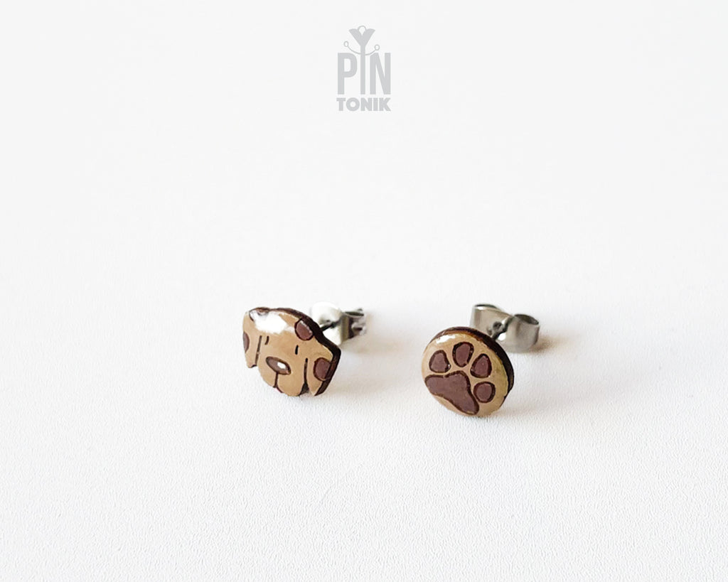 Mismatched hand-painted wooden stud earrings featuring a brown dog face and a matching paw print