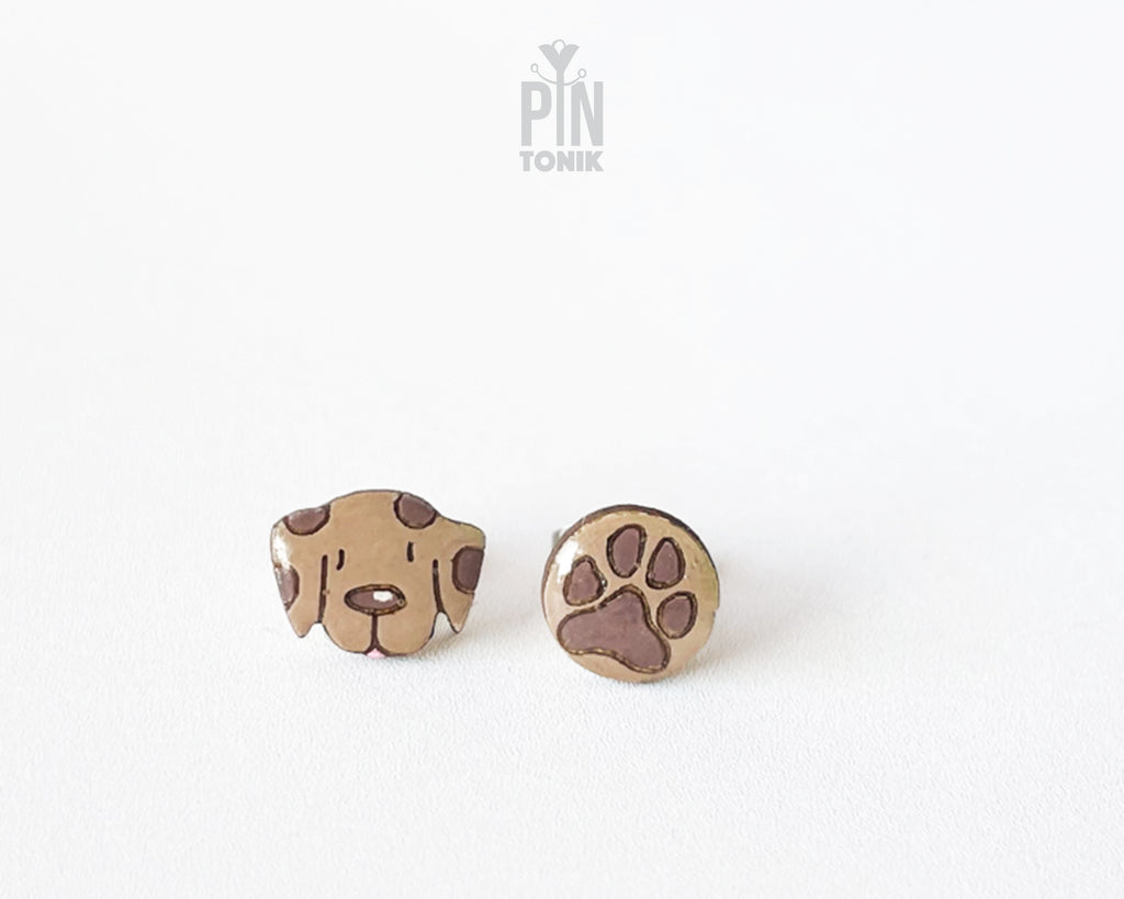 Mismatched hand-painted wooden stud earrings featuring a brown dog face and a matching paw print