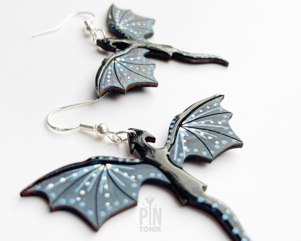 Hand-painted wooden Night dragon dangle earrings with sleek black bodies and speckled blue wing details on sterling silver hooks