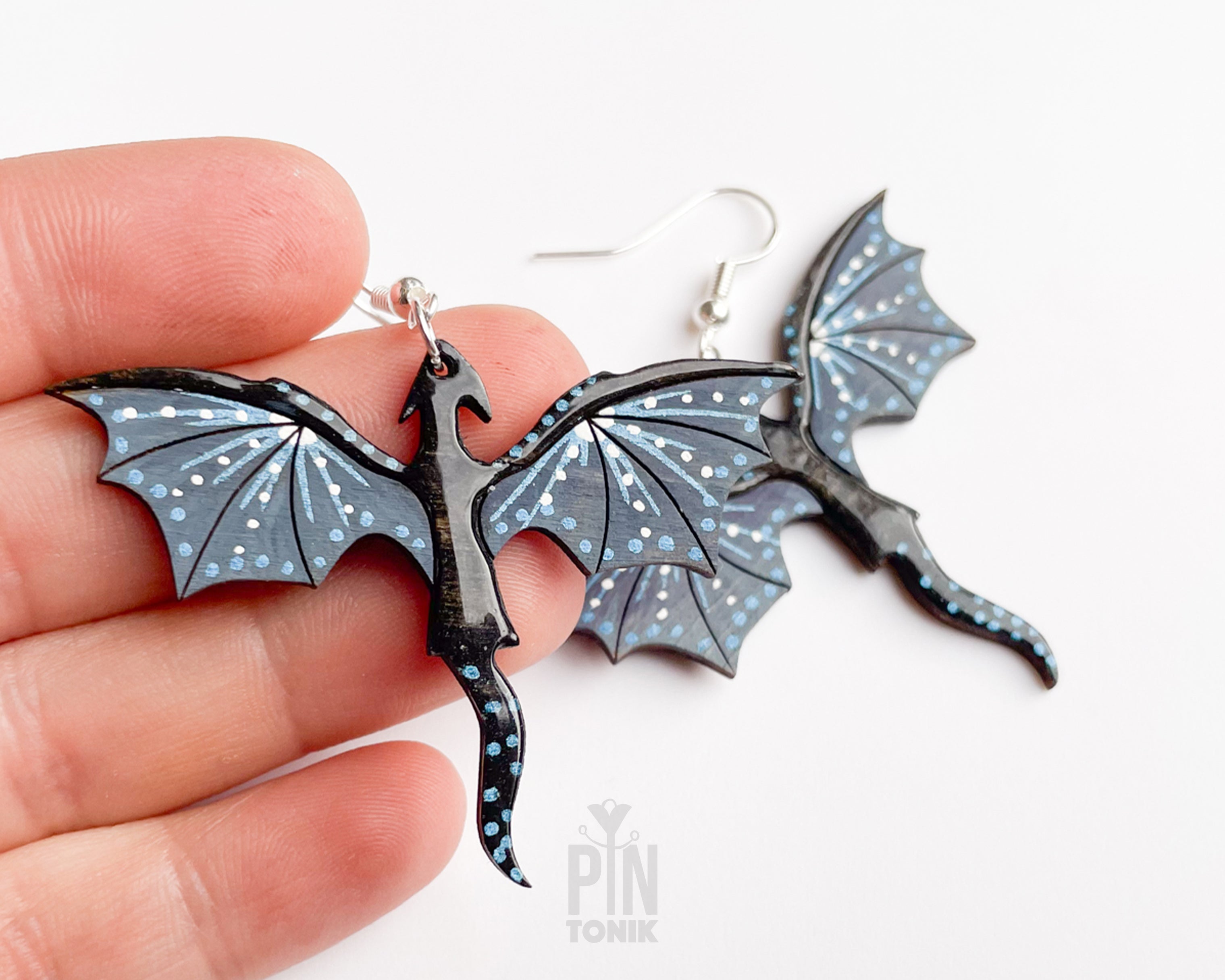Hand-painted wooden Night dragon dangle earrings with sleek black bodies and speckled blue wing details on sterling silver hooks