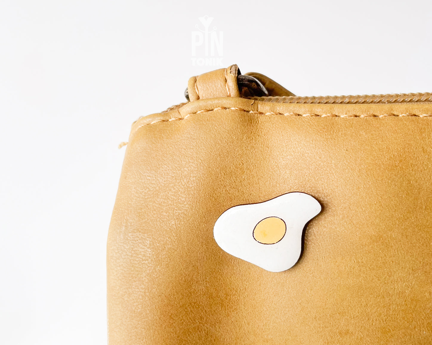 Hand-painted wooden fried egg pin with a bright yellow yolk and white egg white