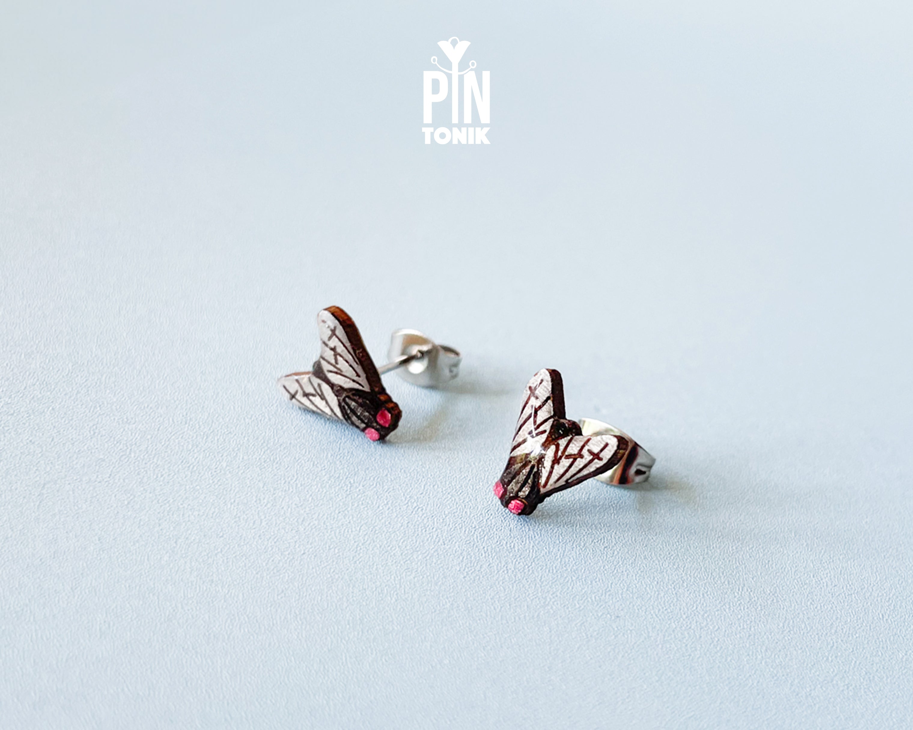 Handmade wooden house fly stud earrings with detailed wings and a black body by PinTonik.
