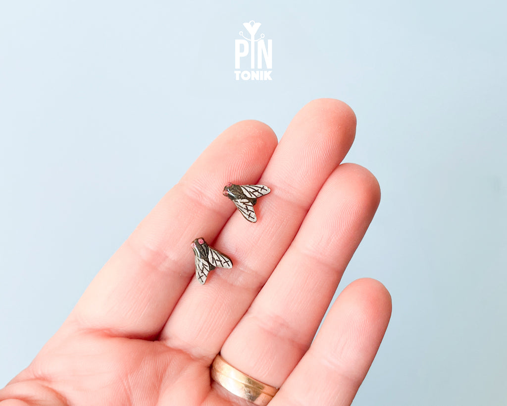 Handmade wooden house fly stud earrings with detailed wings and a black body by PinTonik.