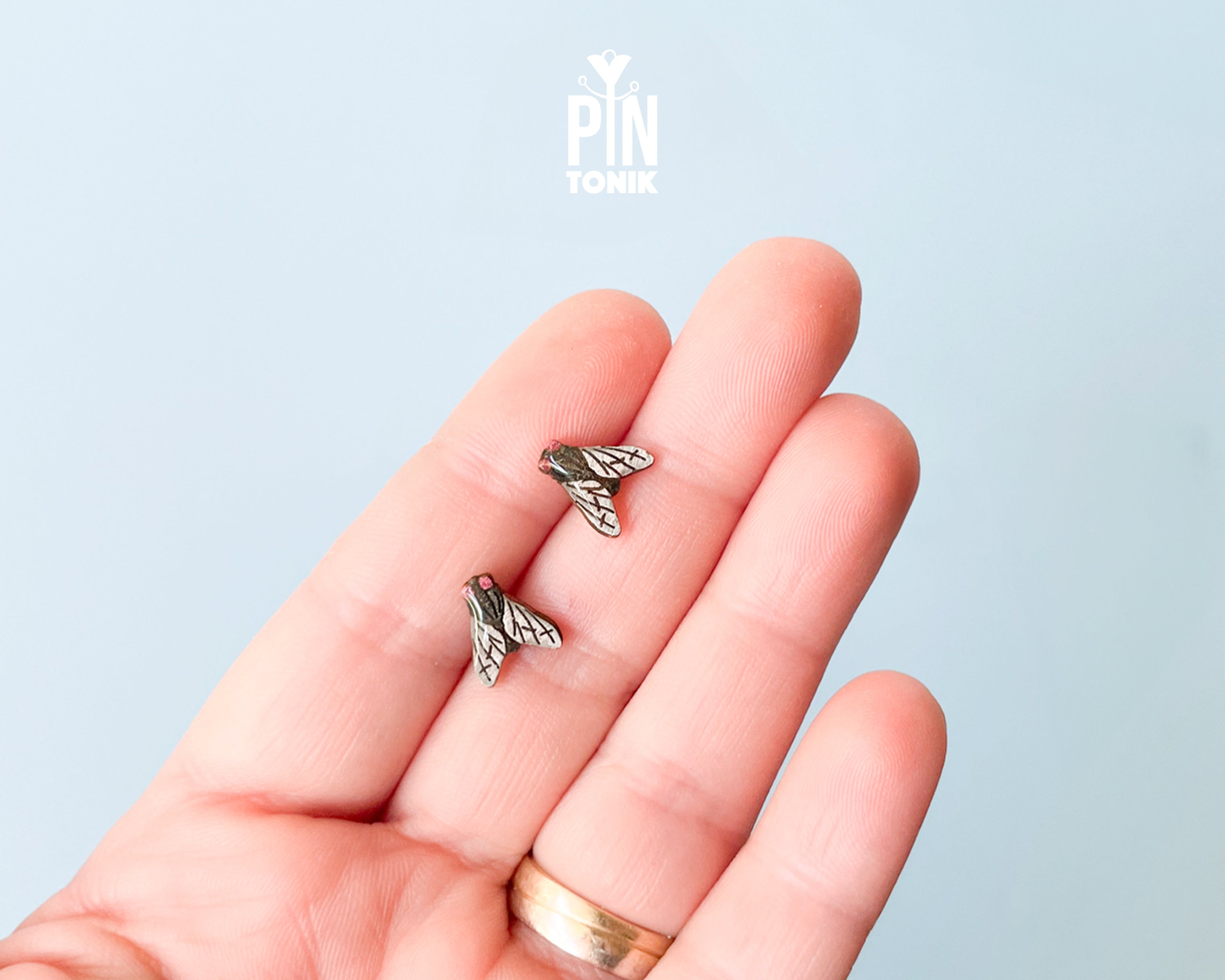 Handmade wooden house fly stud earrings with detailed wings and a black body by PinTonik.