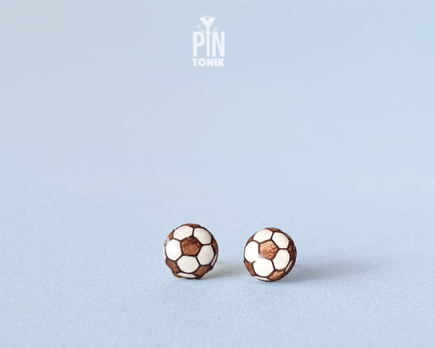 "Handmade wooden soccer ball stud earrings featuring a classic black and white paneled football design by PinTonik."
