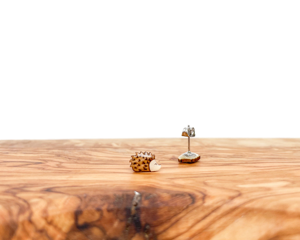Pair of hand-painted wooden hedgehog stud earrings with detailed brown spikes and a high-gloss resin finish