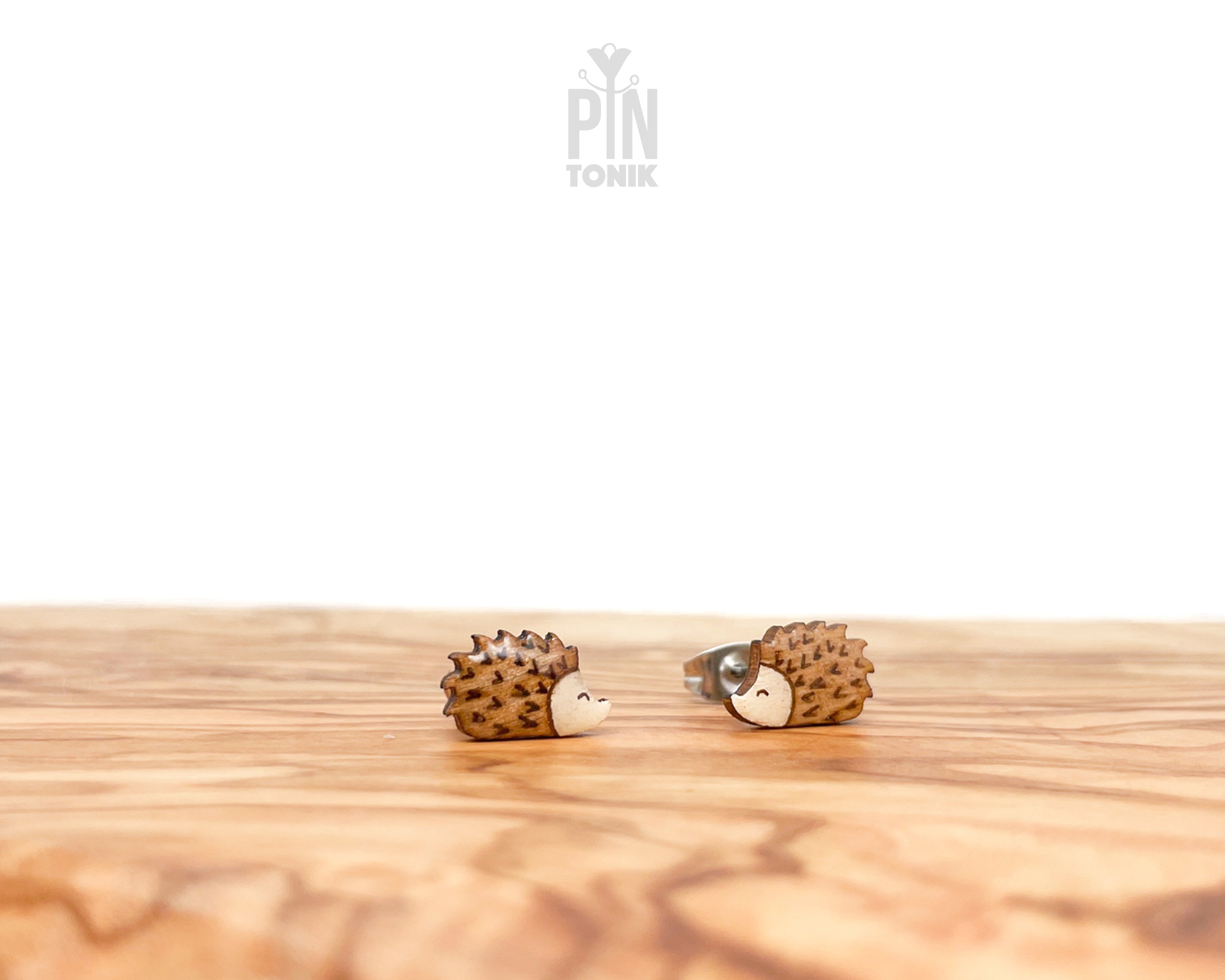 Pair of hand-painted wooden hedgehog stud earrings with detailed brown spikes and a high-gloss resin finish