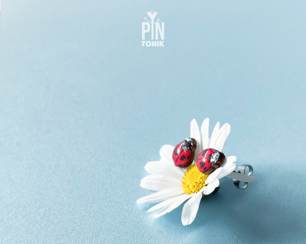 Handmade tiny wooden ladybug stud earrings in classic red and black, measuring a realistic 7-8mm by PinTonik.