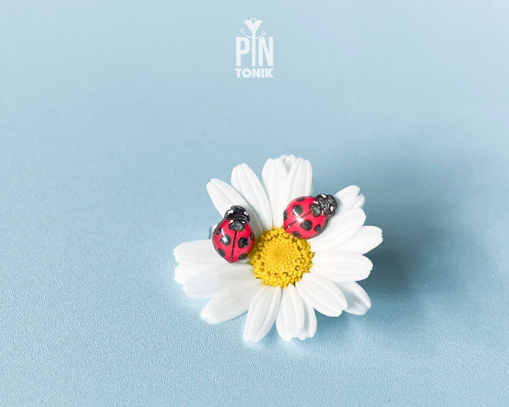 Handmade tiny wooden ladybug stud earrings in classic red and black, measuring a realistic 7-8mm by PinTonik.