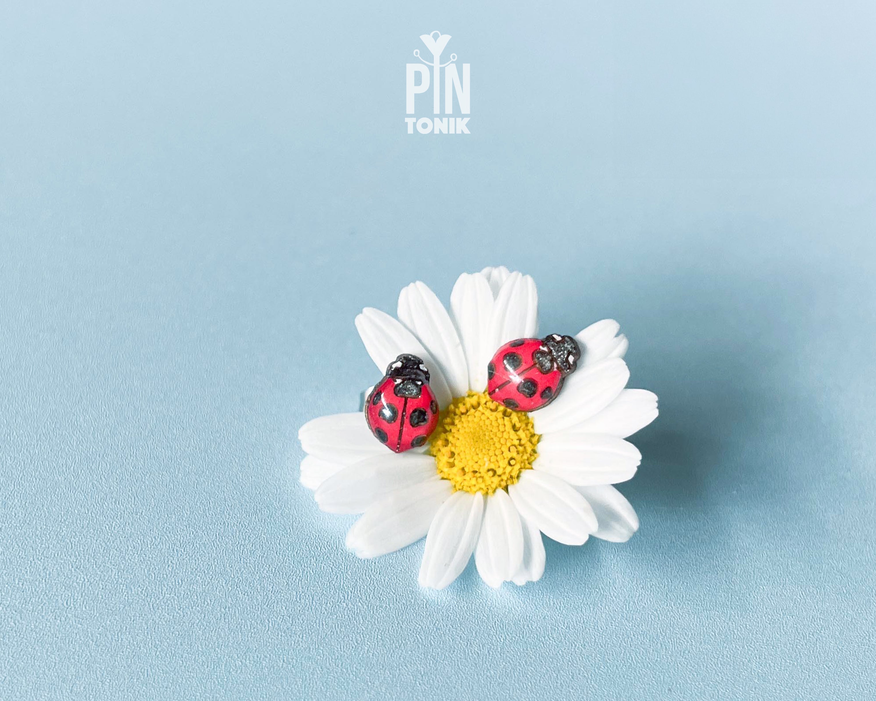 Handmade tiny wooden ladybug stud earrings in classic red and black, measuring a realistic 7-8mm by PinTonik.