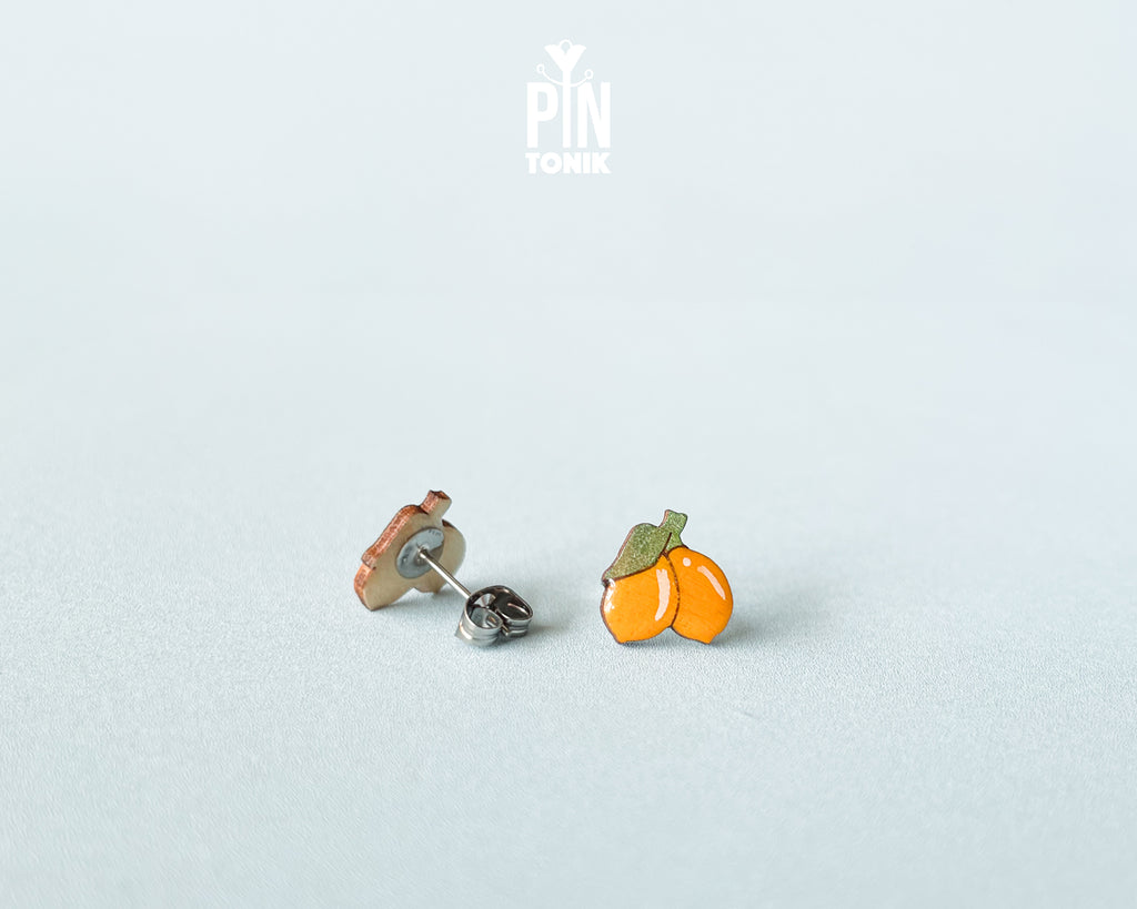 Hand-painted lemon wooden stud earrings on a light blue background, showcasing vibrant yellow citrus design and high-gloss finish.