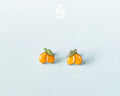 Hand-painted lemon wooden stud earrings on a light blue background, showcasing vibrant yellow citrus design and high-gloss finish.