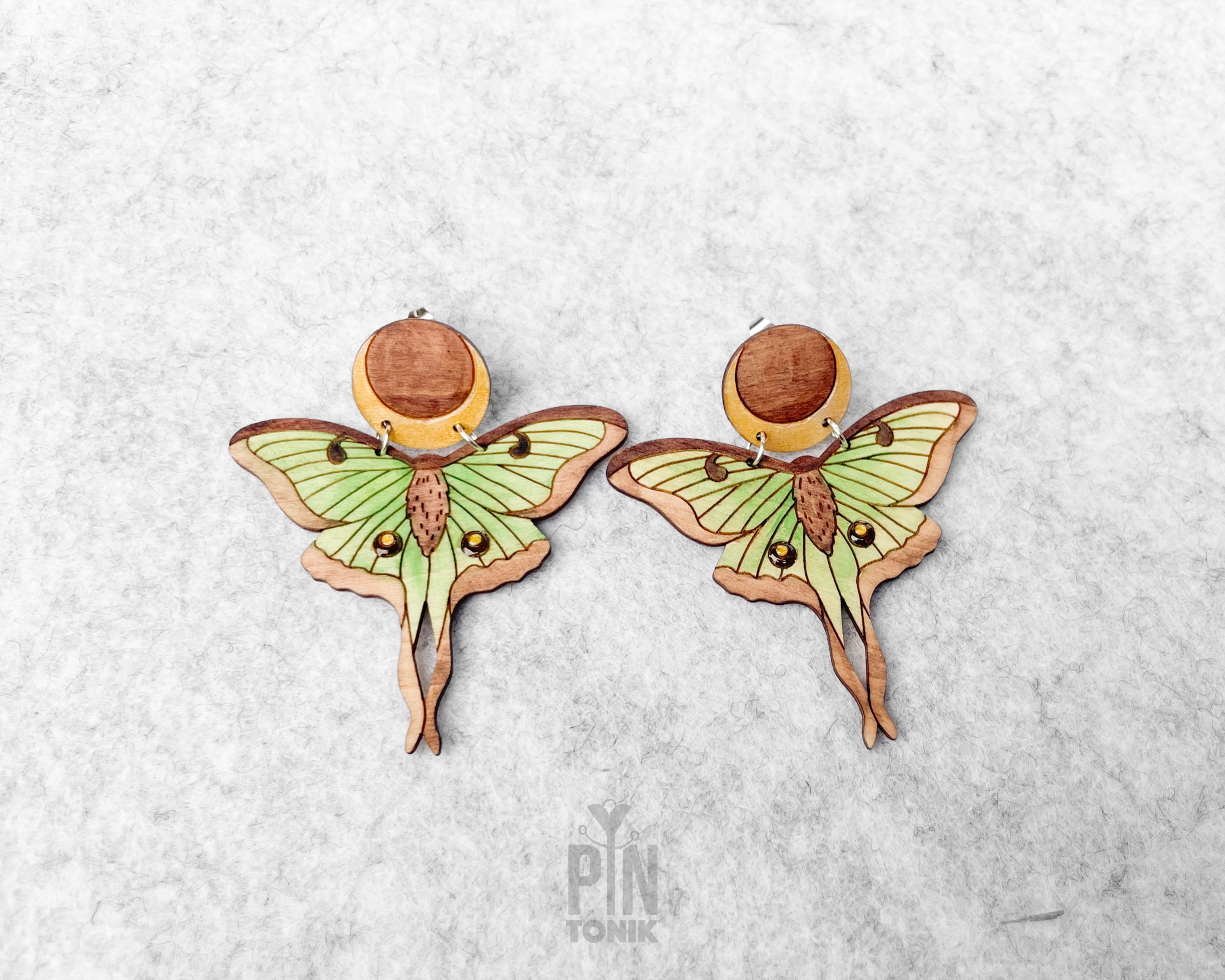 Hand-painted wooden Luna Moth stud earrings featuring green wings and a natural wood-grain moon detail with stainless steel posts