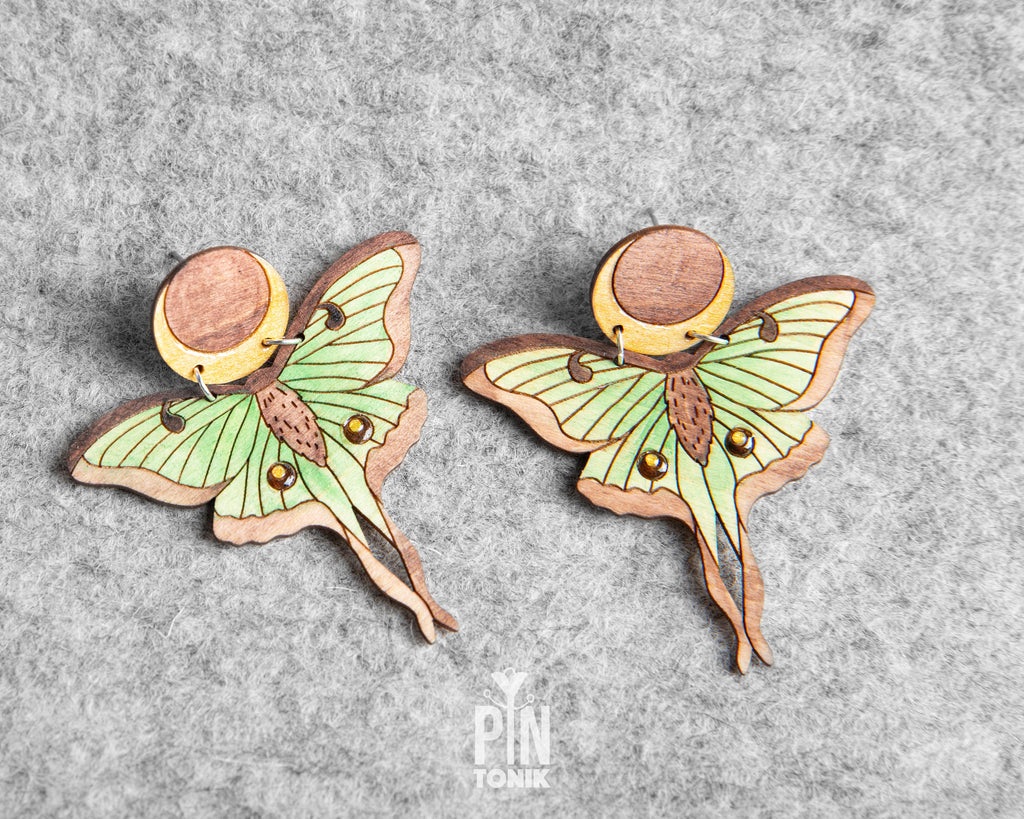 Hand-painted wooden Luna Moth stud earrings featuring green wings and a natural wood-grain moon detail with stainless steel posts
