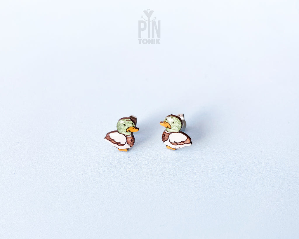Pair of hand-painted wooden mallard duck stud earrings featuring a green head and brown body with a glossy resin finish