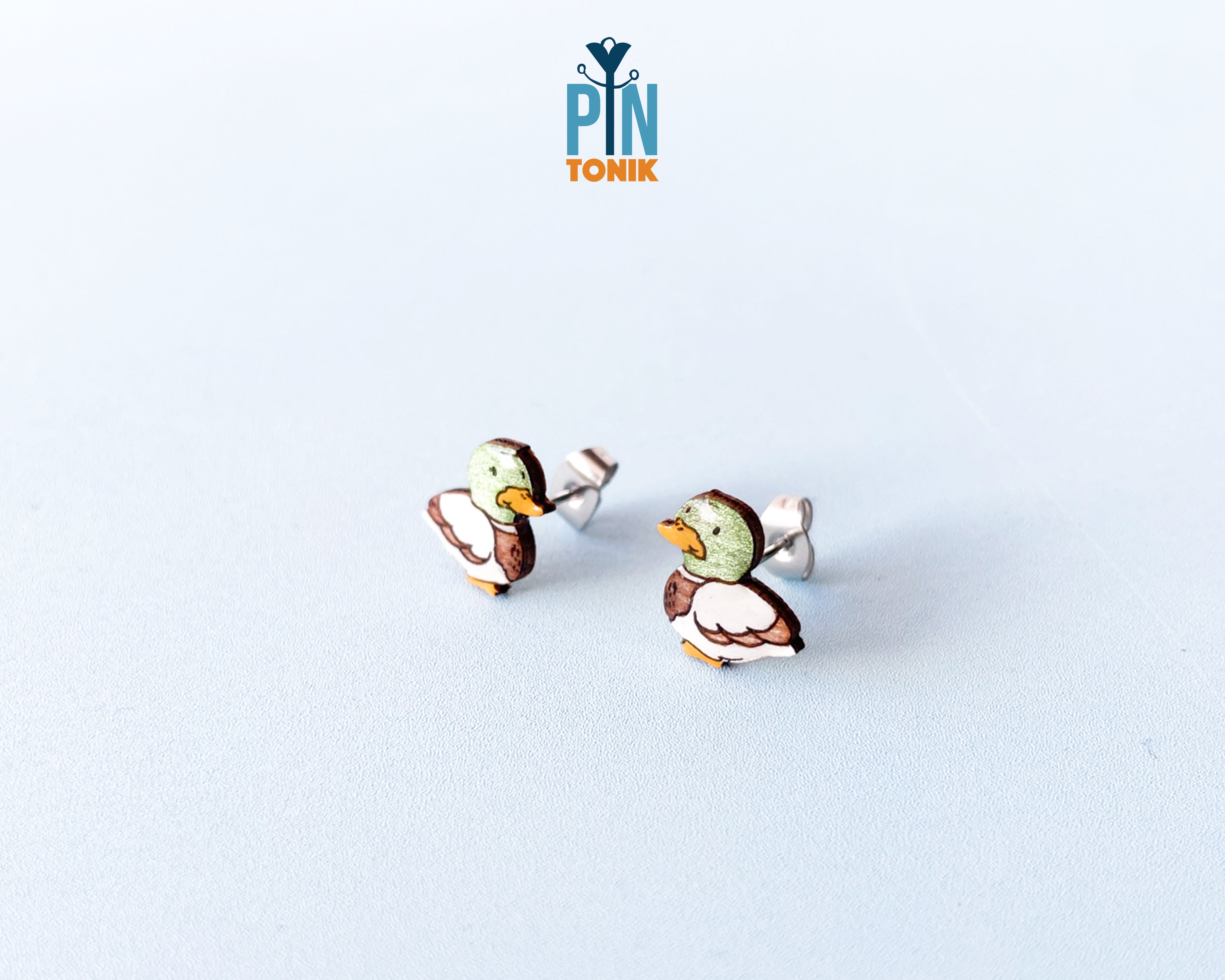 Pair of hand-painted wooden mallard duck stud earrings featuring a green head and brown body with a glossy resin finish